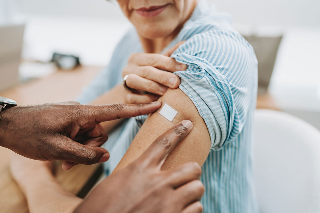 Band aid being put on an arm after injection