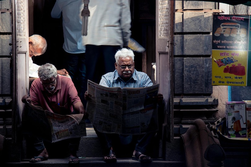 Two men reading a newspaper in Kolhapur, MH, India. Image credit: Dillip Behera