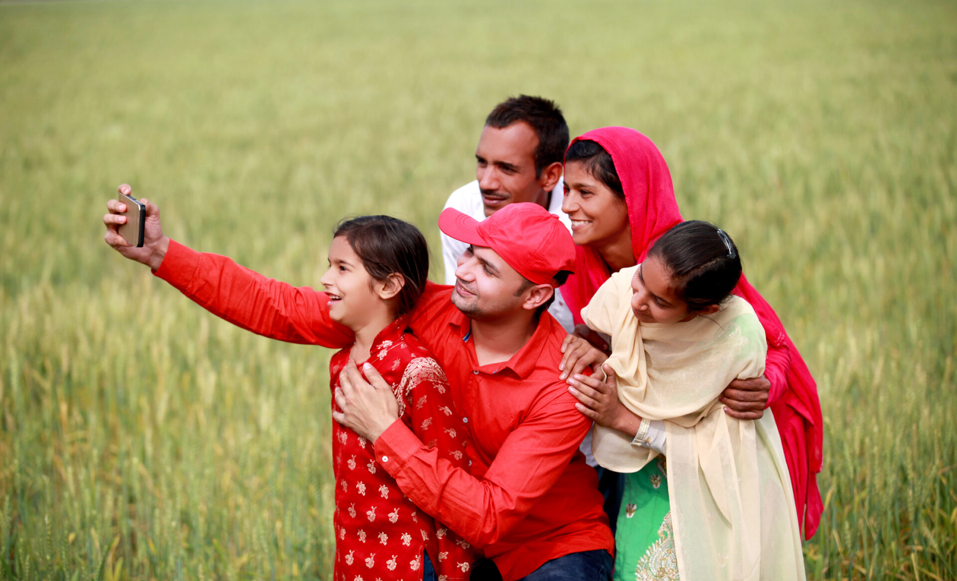 Cheerful Indian family taking selfie outdoor in nature