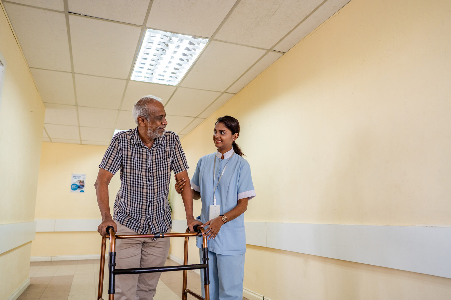 Caretaker assisting senior man with walker