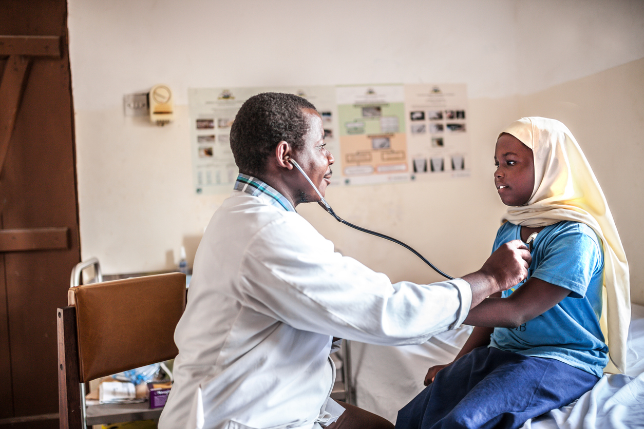 African male doctor examining child